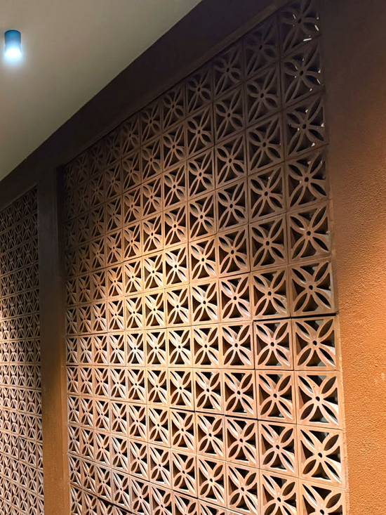 Terracotta jaali screen at night
